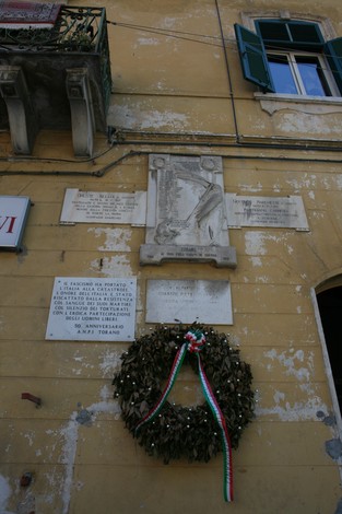 Lapidi commemorative del circolo di Torano, con corona di alloro e scritte a ricordo di eventi storici.