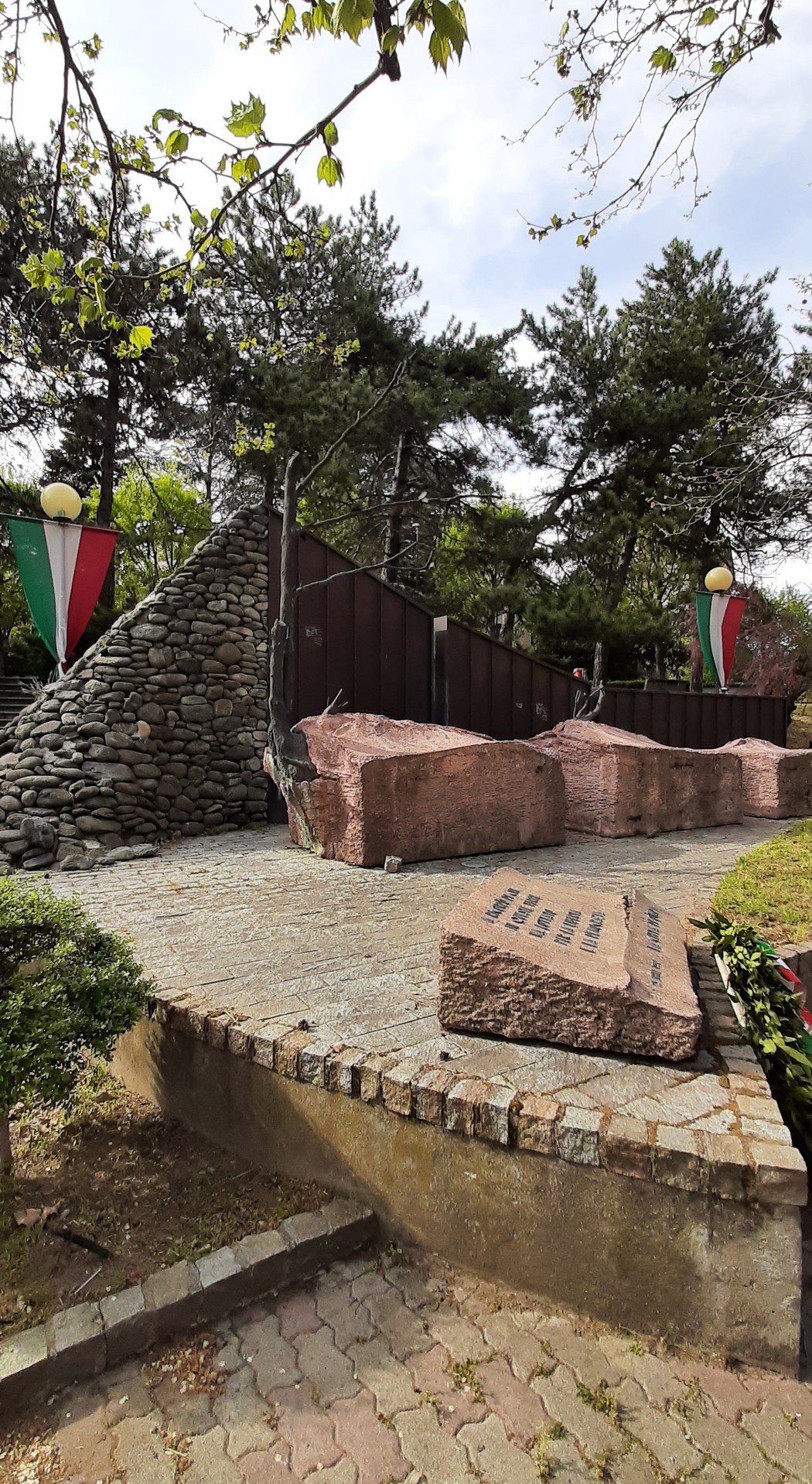 Monumento alla Resistenza di Ovada, commemorazione storica con elementi architettonici e vegetazione circostante.