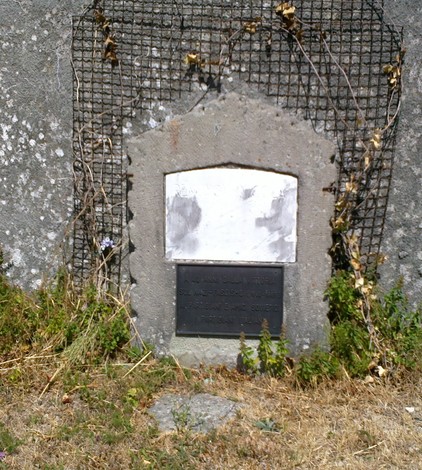 Lapide commemorativa dedicata a Rekunov e Ivan, posizionata in un'area erbosa con vegetazione circostante.