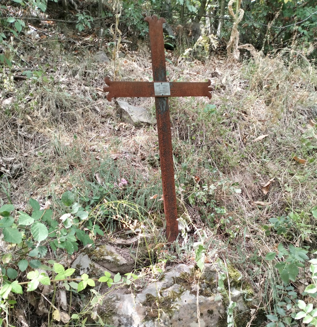 Croce a Cannelli in un contesto naturale, circondata da vegetazione e rocce. Un simbolo di spiritualità e memoria.