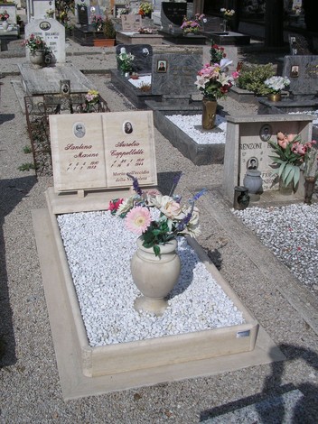 Sepolcro di Cappelletti con fiori decorativi e lapidi commemorative in un cimitero.