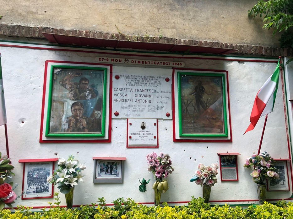 Monumento commemorativo dedicato a Cassetta, Mosca, Andreuzzi e Visentin, con immagini e fiori.