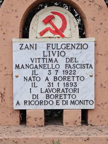 Cippo commemorativo dedicato a Zani Fulgenzio, vittima del fascismo, situato in un contesto naturale.