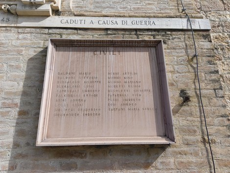 Lapidi commemorative dei caduti in guerra, con nomi incisi su una tavola di pietra.