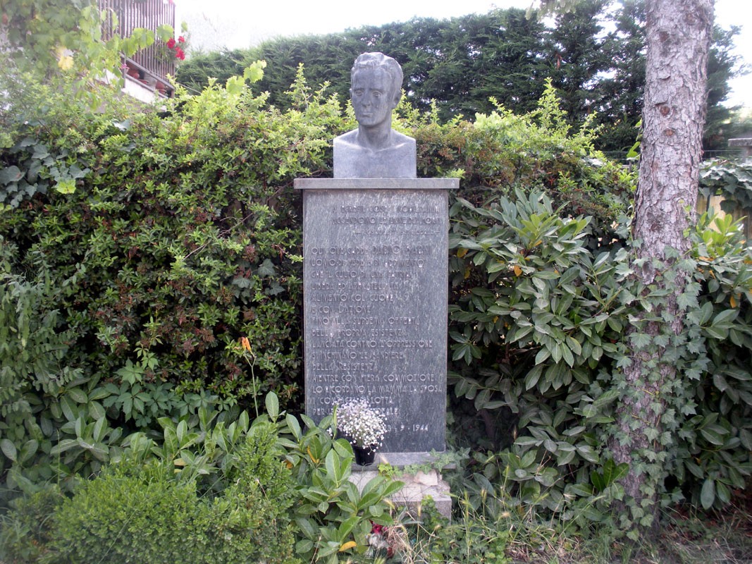Monumento a Barni, dedicato a un significativo personaggio storico, circondato da verde e vegetazione.