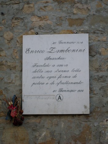 Lapide commemorativa di Enrica Zambonini, anarchica, posta su una parete di pietra.