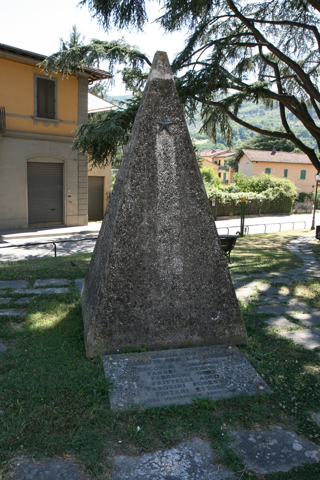 Monumento ai caduti della Resistenza: obelisco commemorativo in granito con simboli della lotta per la libertà.