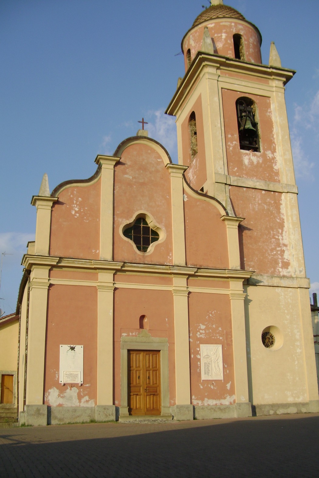 Lapide commemorativa dedicata a Mazzoni e ai caduti, situata accanto a una chiesa storica.