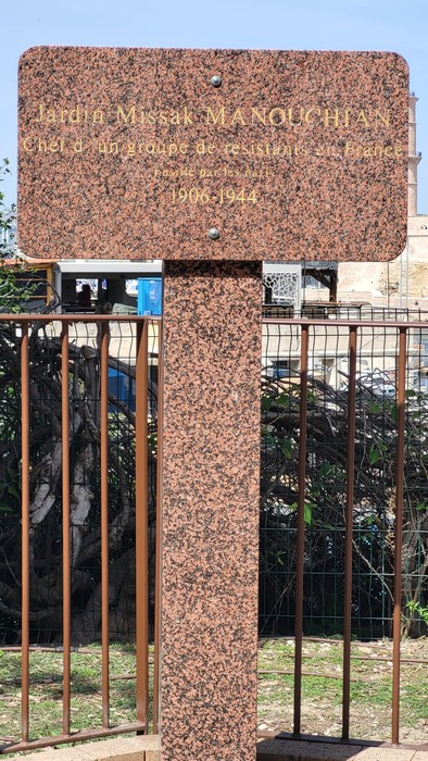 Monumento nel Giardino Missak Manouchian, dedicato alla memoria di un gruppo di resistenti in una cornice verde.