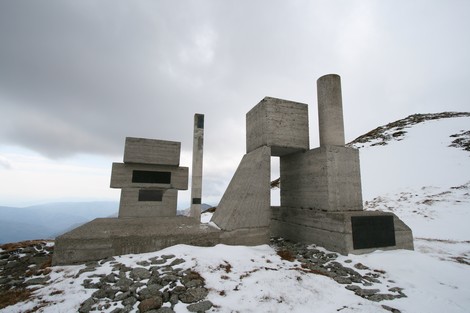 Monumento alla XI Zona "Pippo": struttura in cemento su un paesaggio montano innevato.