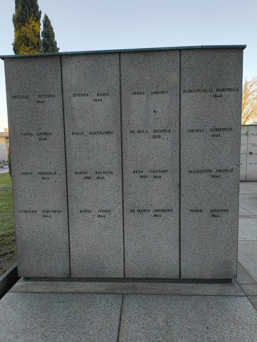 Monumento commemorativo con nomi incisi su pannelli di pietra, situato nel Campo della Gloria.