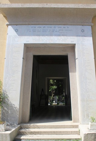 Portale del Cimitero Ebraico con iscrizioni in ebraico e architettura storica. Atmosfera di riflessione e rispetto.