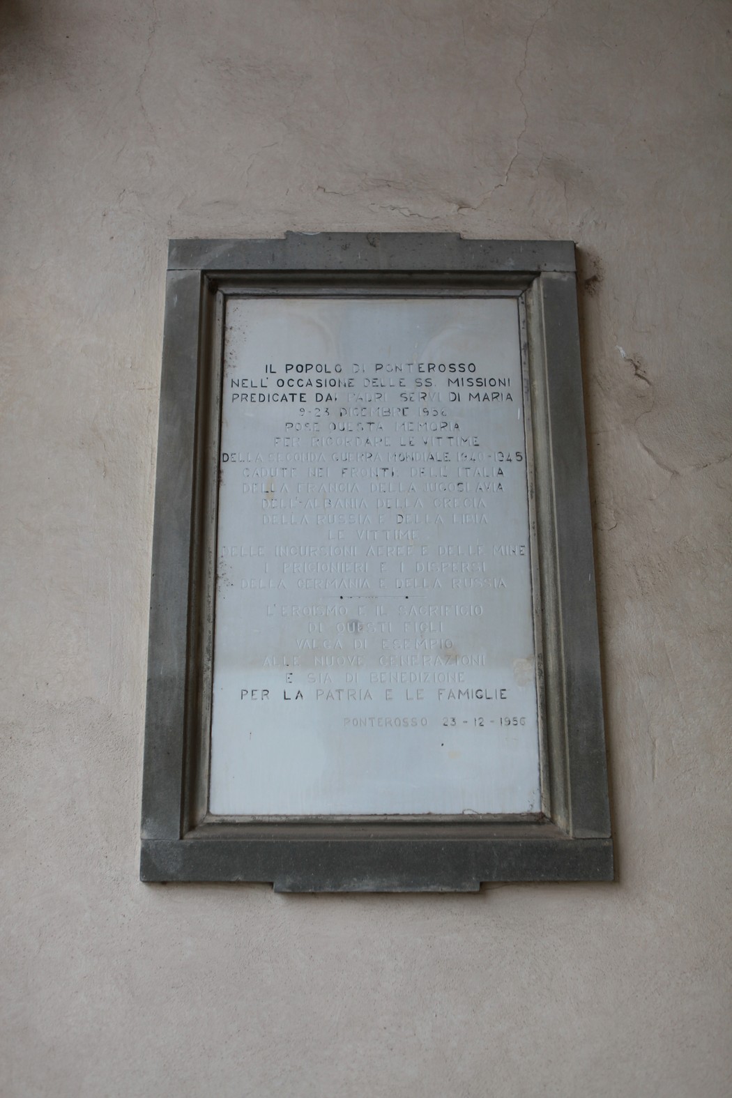 Lapide commemorativa dedicata ai caduti di guerra, in memoria dei sacrifici per la patria e le famiglie.