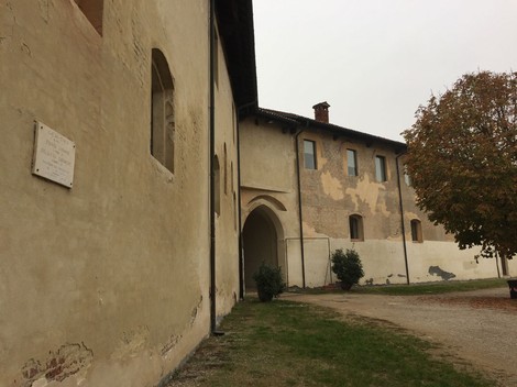 Lapide a Gazzo, con vista su edifici storici e vegetazione circostante. Atmosfera di quiete e storia.