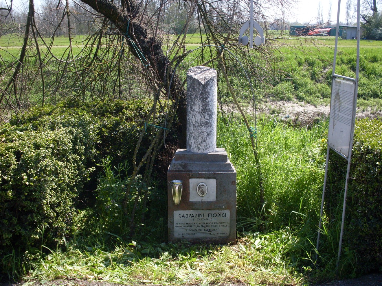 Cippo commemorativo dedicato a Gasparini, situato in un'area verde.