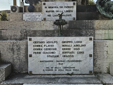 Monumento ai Caduti con lastra commemorativa e simboli di onore e memoria per i patrioti.