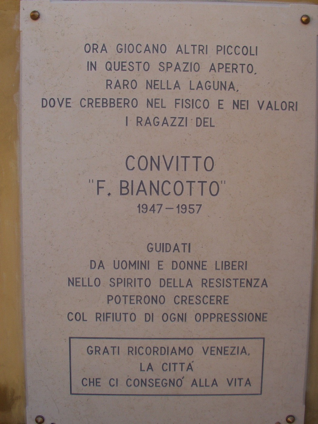Lapide commemorativa dedicata al convitto per orfani di partigiani, simbolo di resistenza e valori di libertà.