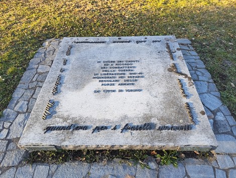 Stele commemorativa dedicata ai caduti delle Forze Armate, collocata in un'area verde.