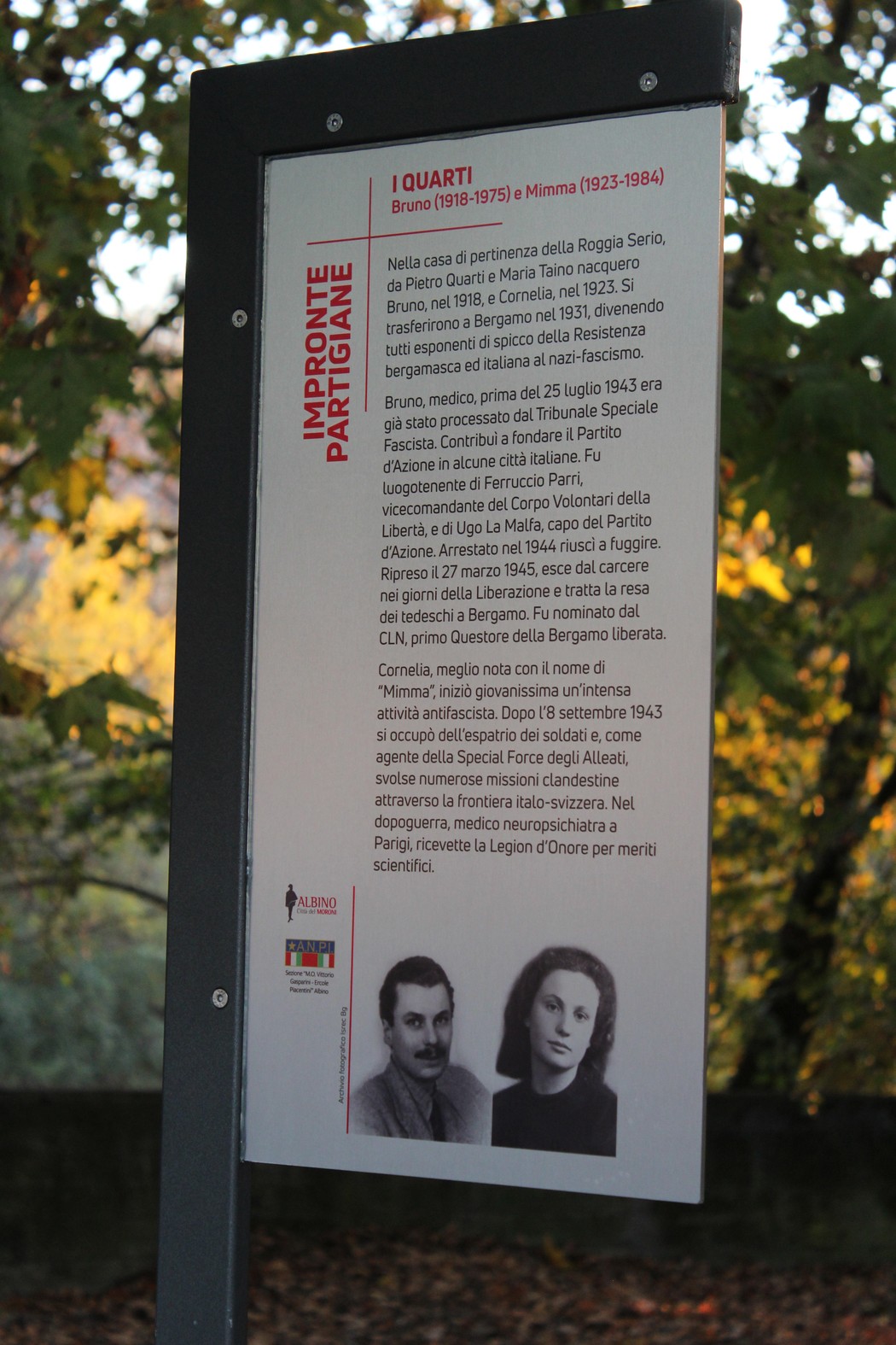 Targhetta commemorativa dedicata ai fratelli Quarti, partigiani italiani, con dettagli sulla loro vita e azioni.
