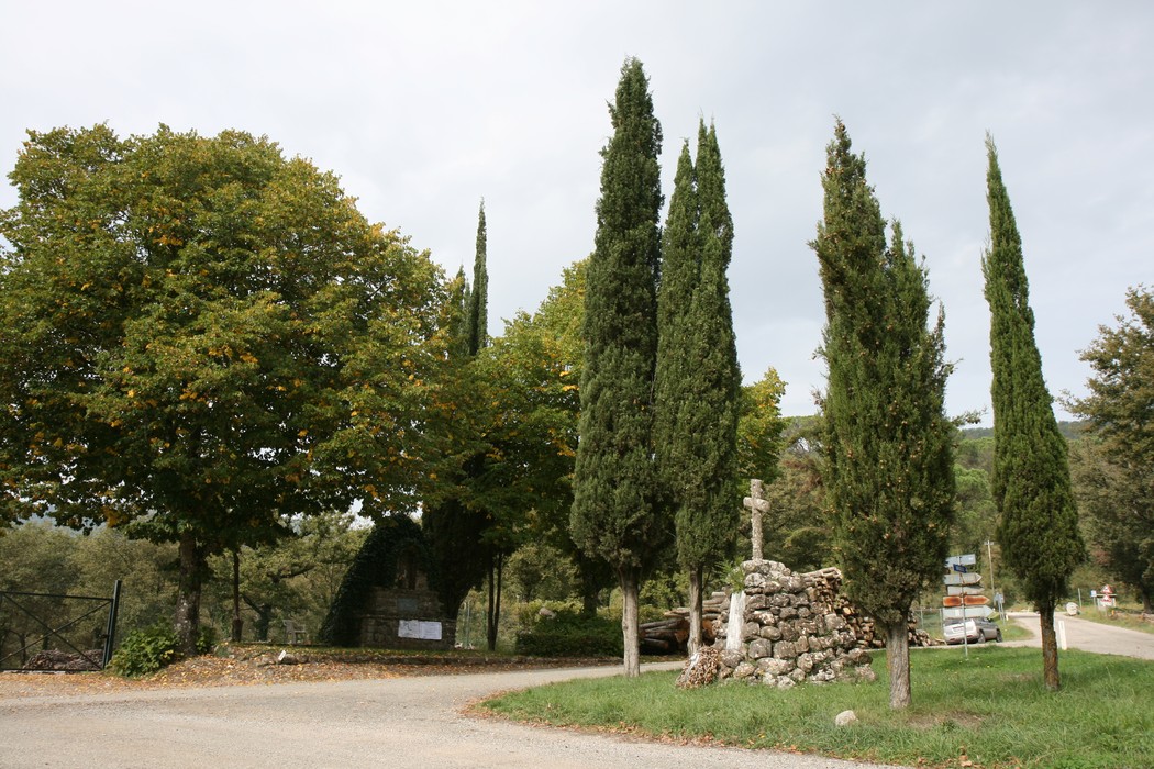Tabernacolo di Falzano circondato da alberi e cipressi, immerso nella tranquillità della natura.