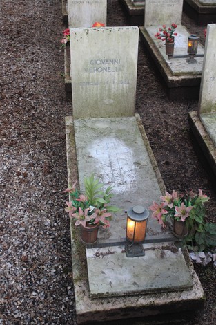 Tombe monumentali decorate con fiori, in memoria dei caduti per la Libertà. Atmosfera rispettosa e commemorativa.