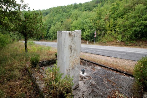 Cippo commemorativo dedicato ai partigiani uccisi, immerso nella natura a Colle di Postignano.