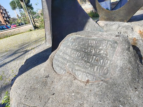 Monumento ai valori futuribili della Resistenza, con una base in pietra e dettagli artistici in metallo.