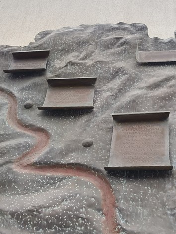 Monumento ai partigiani caduti di Pianoro, con lastre commemorative incassate in una superficie monumentale.