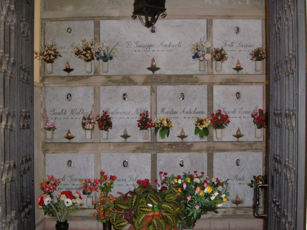 Sacrario dei partigiani di San Possidonio con lapidi marmoree e fiori freschi in omaggio.