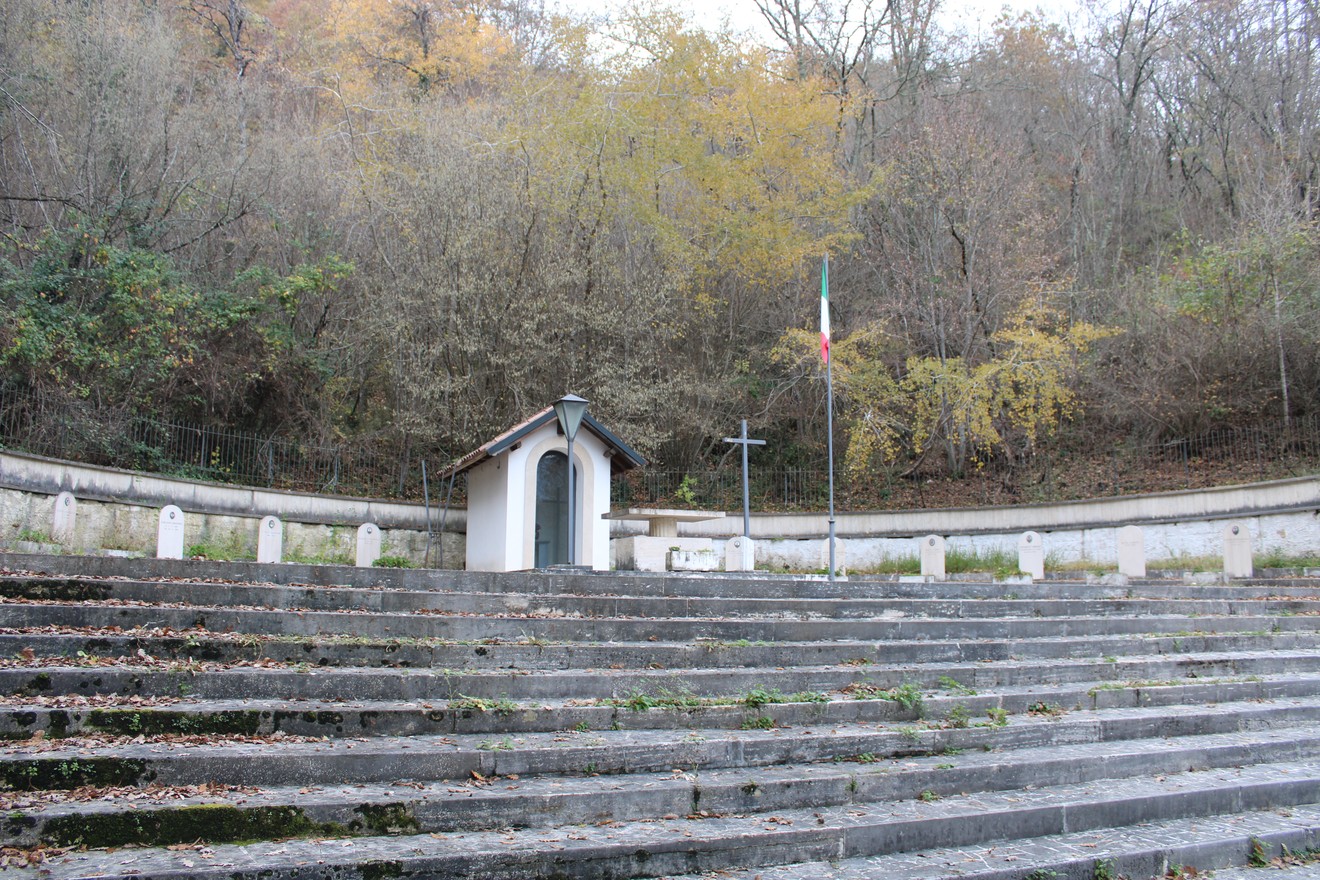 Sacrario dei Martiri di Cicchetti, un luogo di memoria immerso nella natura, circondato da alberi e gradoni in pietra.