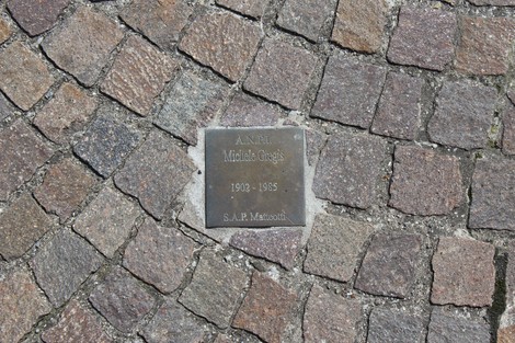 Pietra d'inciampo commemorativa dedicata a un partigiano, incastonata nel pavimento di una strada.