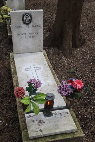 Tomba perpetua con fiori e una lampada, commemorando un caduto per la Libertà.