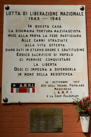 Lapide commemorativa dedicata alla lotta di liberazione nazionale, con riferimento a eventi storici e all'impegno della resistenza.