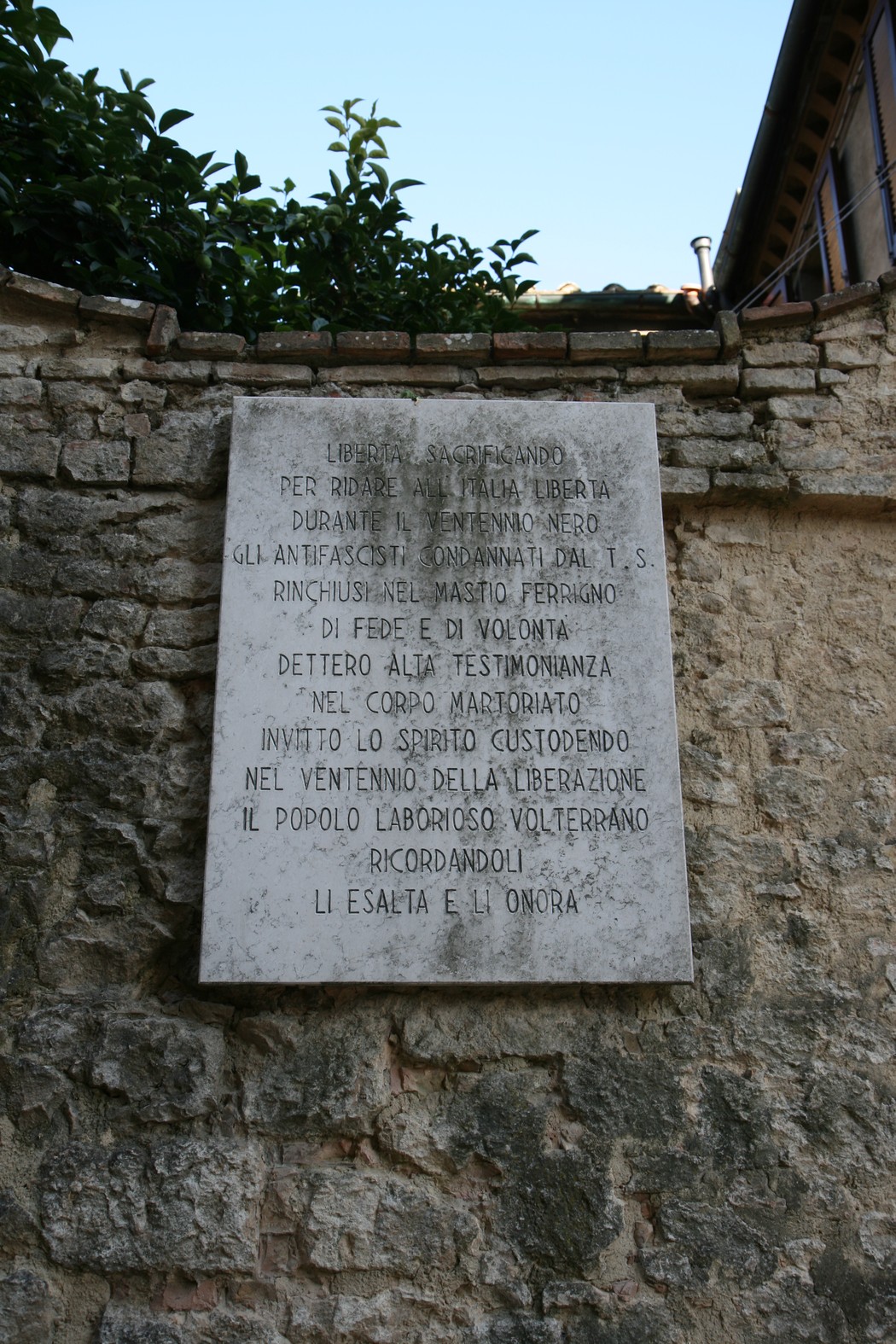 Lapide commemorativa al Mastio di Volterra, simbolo di libertà e testimonianza della storia locale.