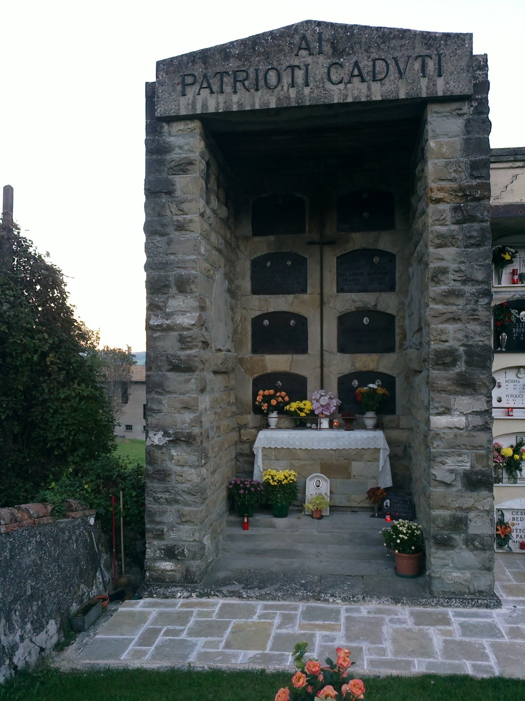 Sacrario dedicato ai partigiani di Vezzano, con commemorazioni e fiori in un'atmosfera di rispetto e memoria.