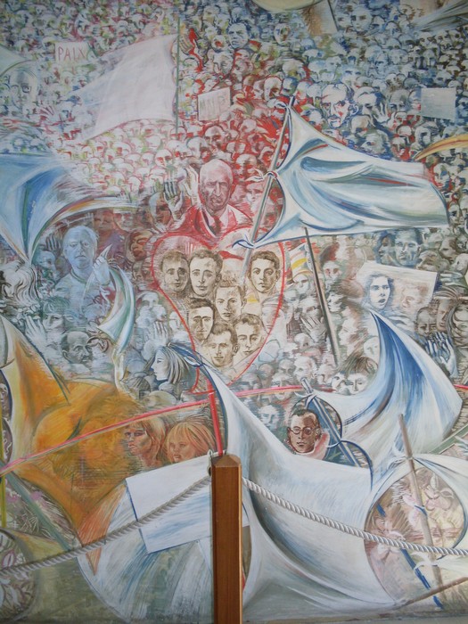 Murale che celebra la pace, ricco di figure e simboli che rappresentano l'unità e la speranza per un futuro migliore.