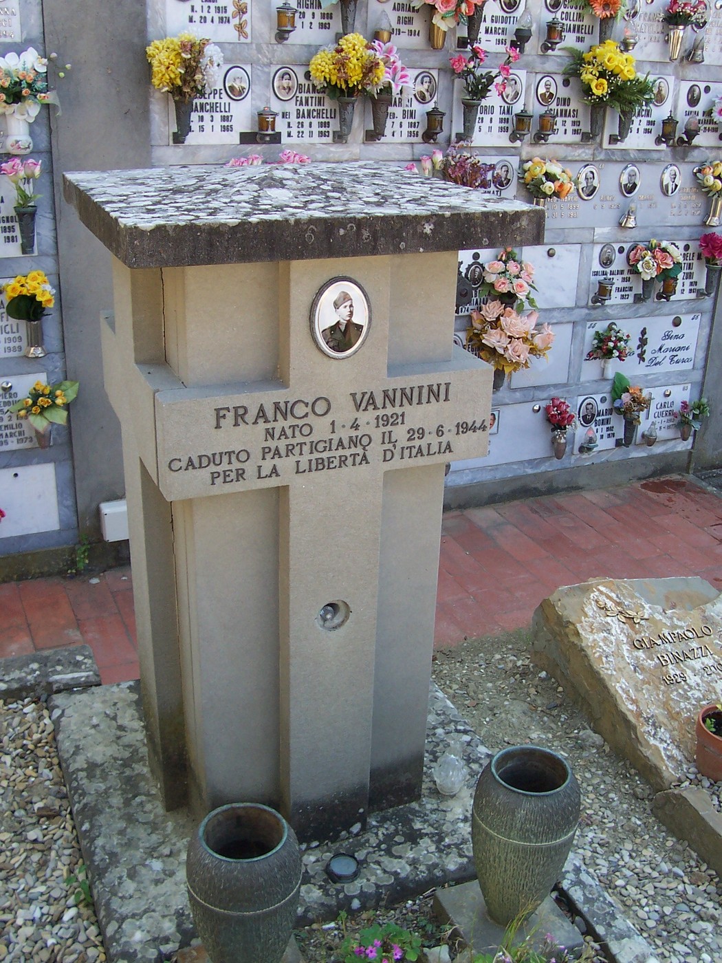 Sepolcro di Franco Vannini, caduto partigiano per la libertà d'Italia, con fiori e decorazioni commemorative.