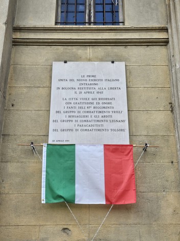 Lapide commemorativa all'ingresso dell'Esercito cobelligerante italiano a Bologna, con bandiera italiana.