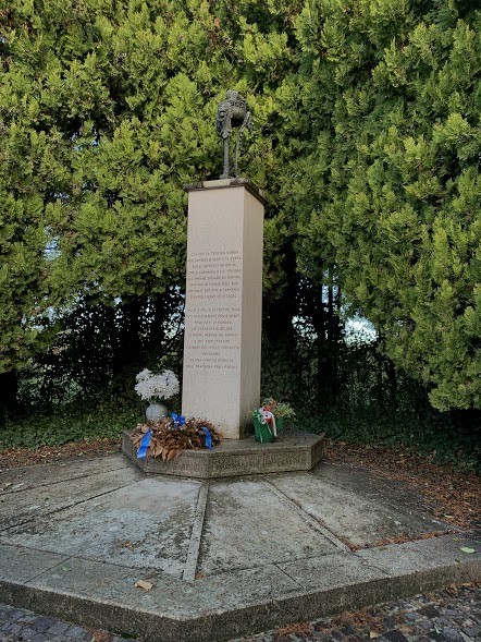 Monumento commemorativo dedicato ai martiri del 5 settembre 1944, circondato da alberi e omaggi floreali.