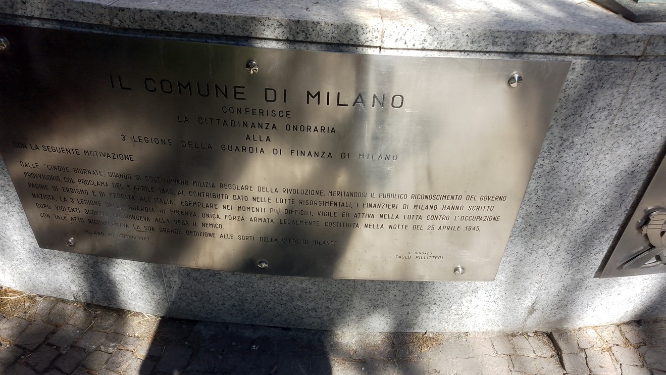Monumento ai finanzieri lombardi, onore ai caduti, con piastra commemorativa e dettagli architettonici.