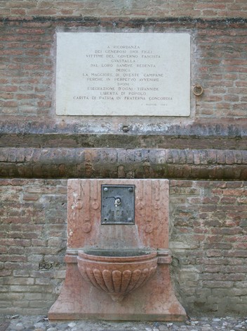 Lapide commemorativa dedicata alle vittime del regime fascista, posta su una muratura in mattoni.