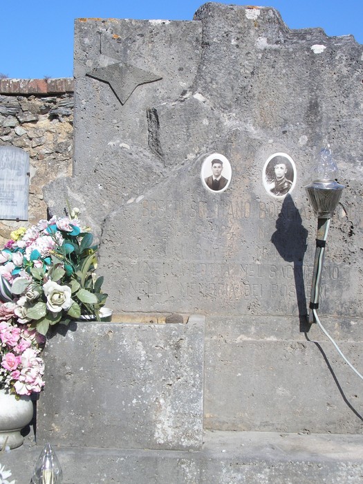 Sepolcro monumentale con decorazioni e doppia fotografia commemorativa.