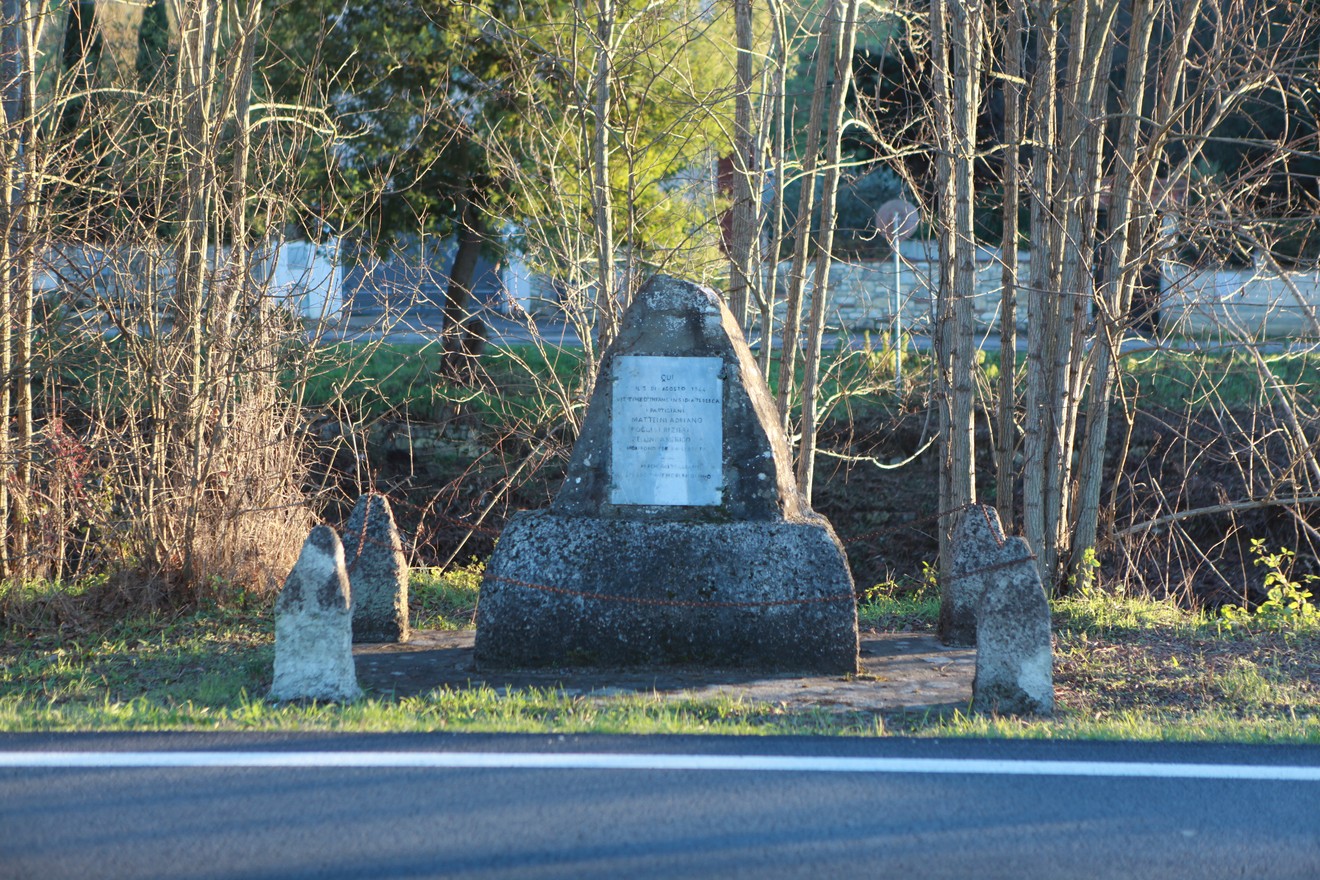Monumento commemorativo ai caduti Matteini, Poggesi e Zellini, circondato dalla vegetazione.