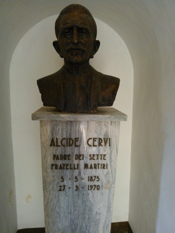 Cippo dedicato ad Alcide Cervi, padre dei sette Fratelli Martiri, con un busto in bronzo e colonne di marmo.
