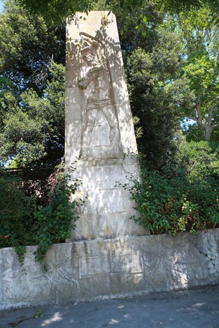 Monumento ai militari caduti in prigionia, caratterizzato da rilievi e un design imponente, immerso nel verde.