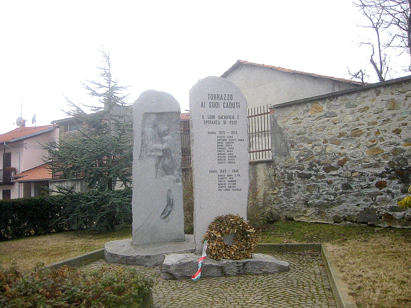 Monumento ai caduti di Torrazzo, dedicato alla memoria dei soldati e alla pace, circondato da un giardino.