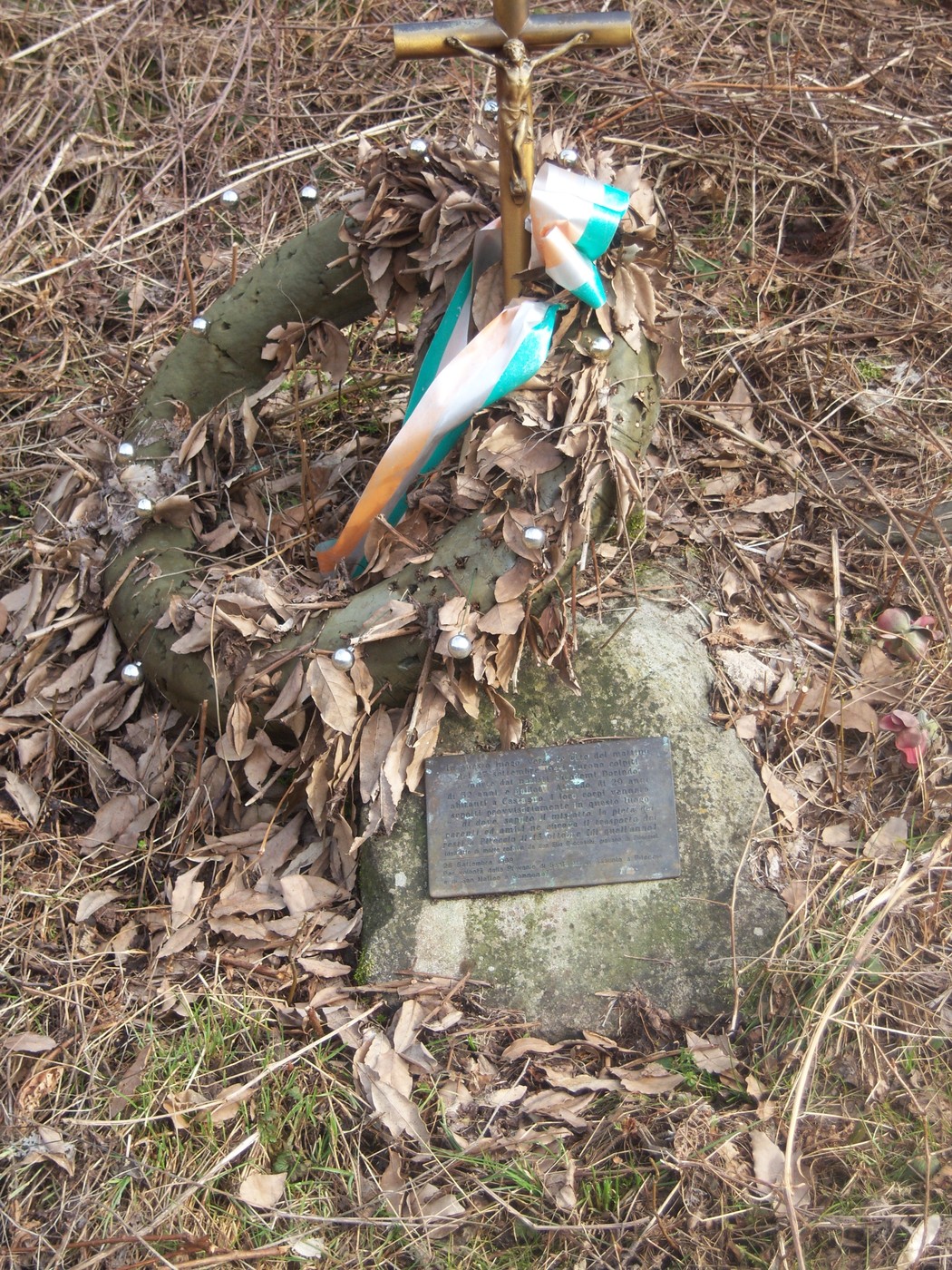 Cippo commemorativo di Nicodemi e Ballotti, circondato da foglie e decorazioni.