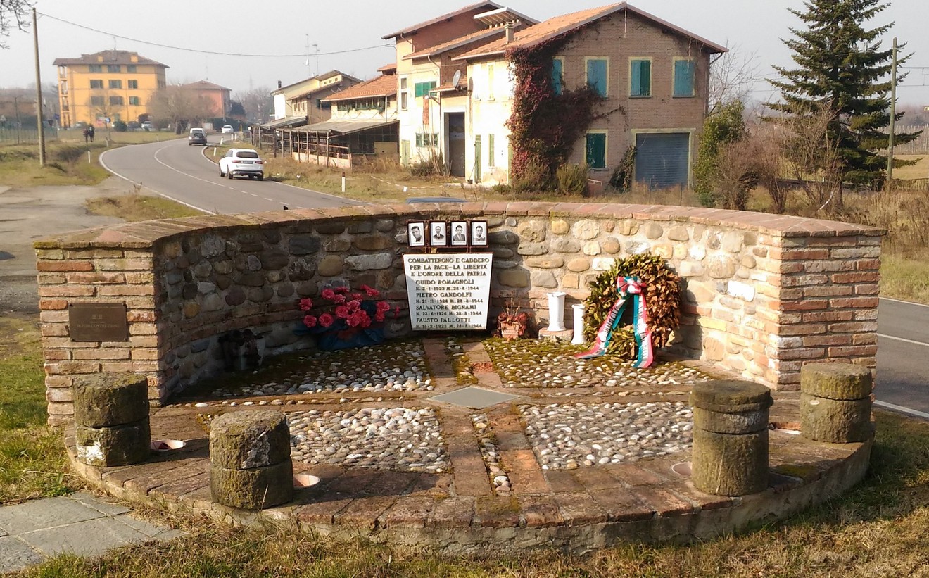 Monumento dedicato a Romagnoli, Gandolfi, Bignami e Pallotti, situato in un'area rurale con vegetazione circostante.