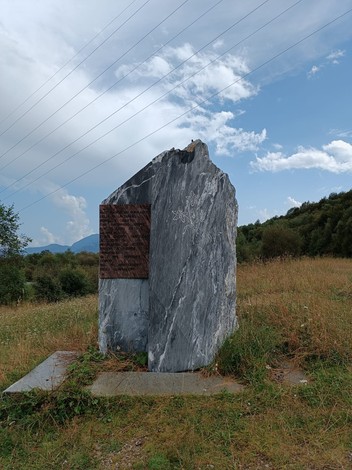 Monumento dedicato ai partigiani delle Valli Tanaro, Mongia e Casotto, circondato da natura e cielo.