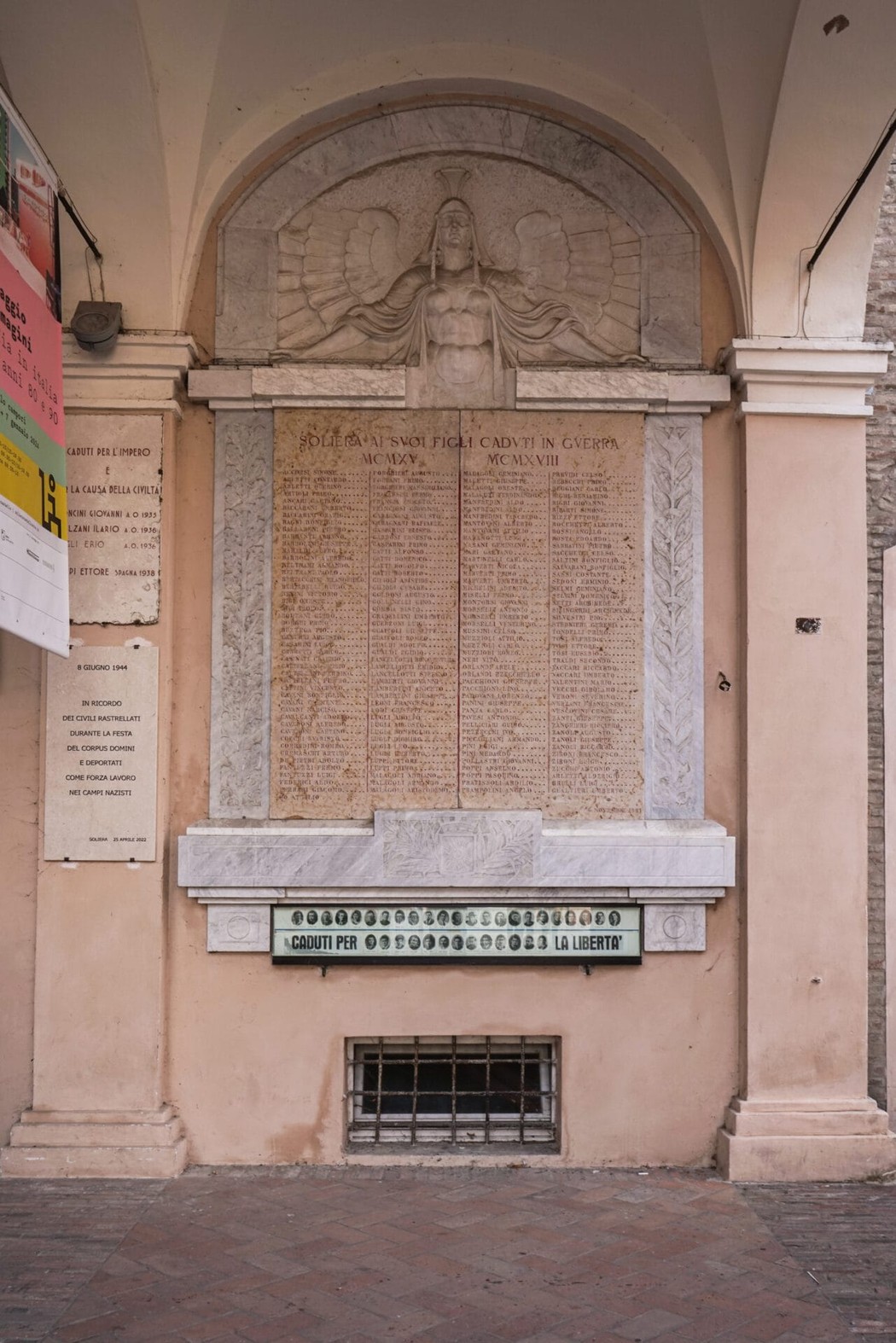 Lapide commemorativa che onora i caduti di Soliera, con rilievi e iscrizioni particolari.